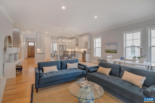 living room with crown molding, light wood finished floors, and recessed lighting