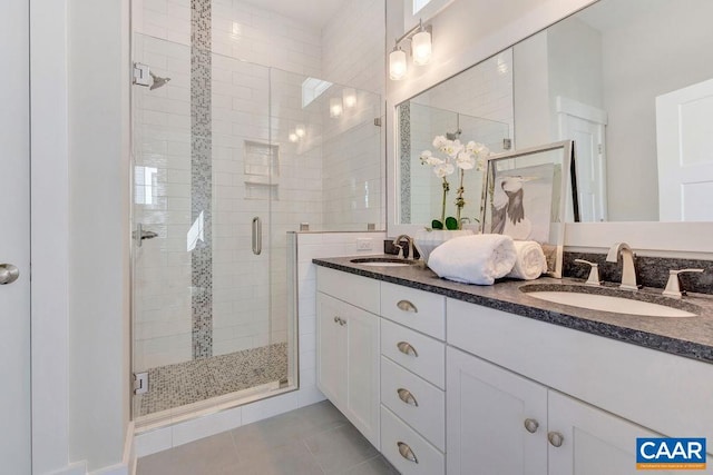 full bath featuring tile patterned flooring, a shower stall, and a sink