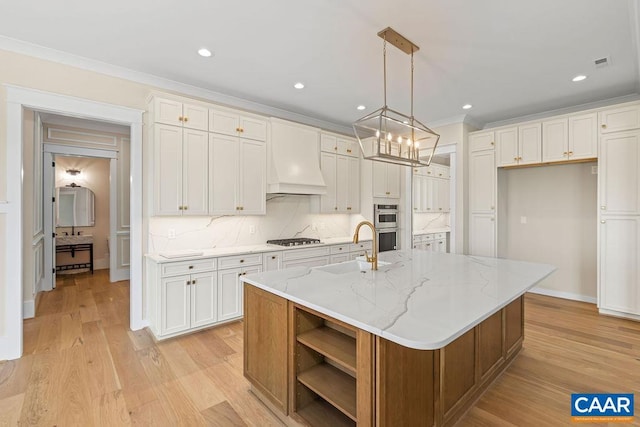 100 Stable Ln, Lynchburg, VA 24503 - kitchen with stainless steel gas stovetop, recessed lighting, custom exhaust hood, backsplash, and a kitchen island with sink