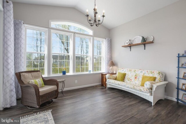 living area featuring a chandelier, lofted ceiling, wood finished floors, and baseboards