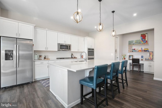 kitchen with stainless steel appliances, dark wood-style floors, a sink, light countertops, and recessed lighting