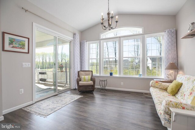 living area with a chandelier, healthy amount of natural light, lofted ceiling, dark wood-type flooring, and baseboards