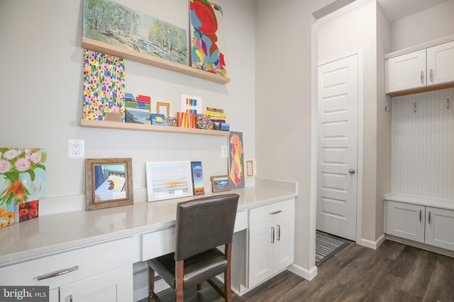 office space featuring built in study area, dark wood finished floors, and baseboards