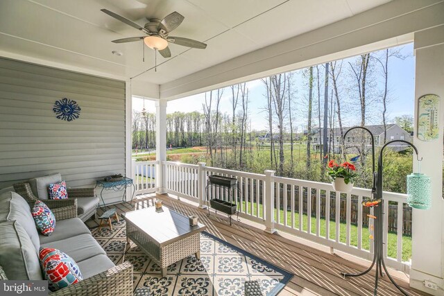 wooden terrace with ceiling fan and an outdoor living space