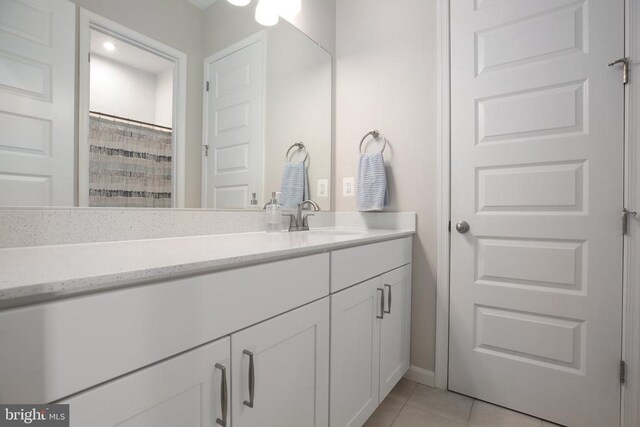 bathroom featuring tile patterned flooring, vanity, and baseboards