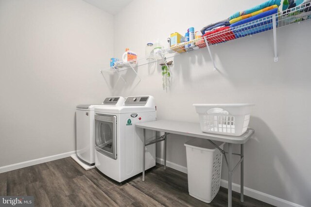 clothes washing area featuring independent washer and dryer, dark wood-style flooring, and baseboards