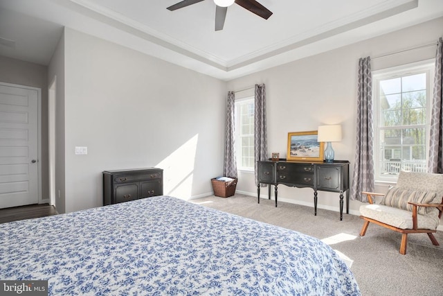 carpeted bedroom with multiple windows, ornamental molding, baseboards, and a ceiling fan