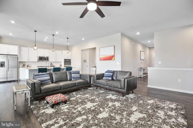living area featuring ceiling fan, dark wood-type flooring, recessed lighting, and baseboards