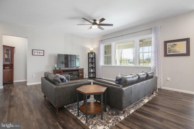 living room with wood finished floors, a ceiling fan, and baseboards