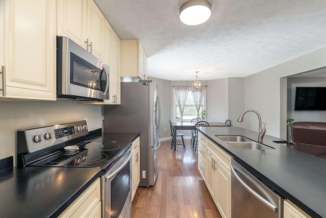 324 Rustic Ave, Broadway, VA 22815 - kitchen featuring stainless steel appliances, a sink, dark countertops, cream cabinetry, and a textured ceiling