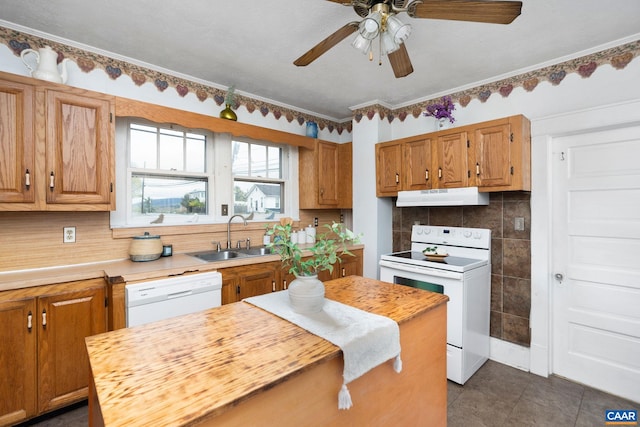 kitchen with a sink, white appliances, under cabinet range hood, ceiling fan, and light countertops