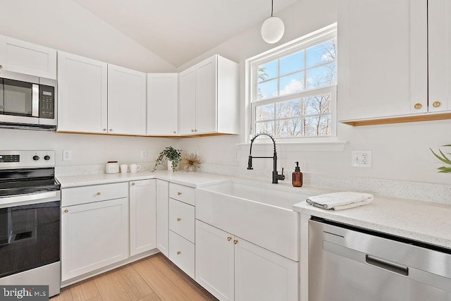 6000 Bills Rd, Mineral, VA 23117 - kitchen with stainless steel appliances, white cabinetry, vaulted ceiling, light wood-type flooring, and a sink