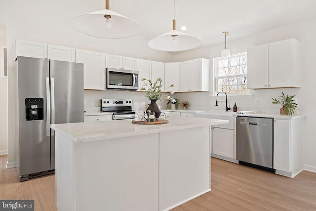 6000 Bills Rd, Mineral, VA 23117 - kitchen featuring appliances with stainless steel finishes, light wood finished floors, white cabinets, and a kitchen island