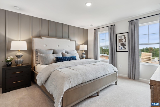 bedroom featuring light colored carpet and baseboards