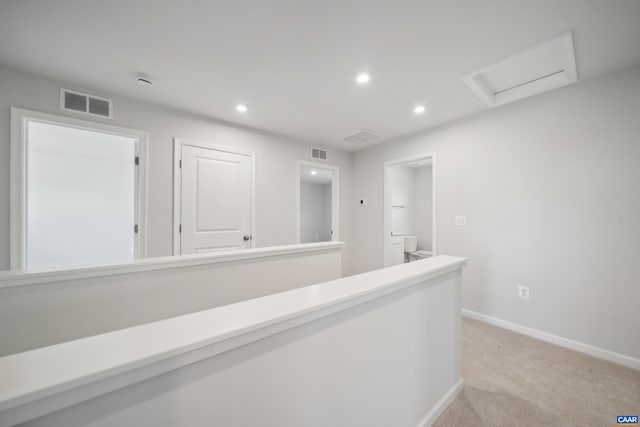 hall featuring light colored carpet, baseboards, visible vents, and recessed lighting