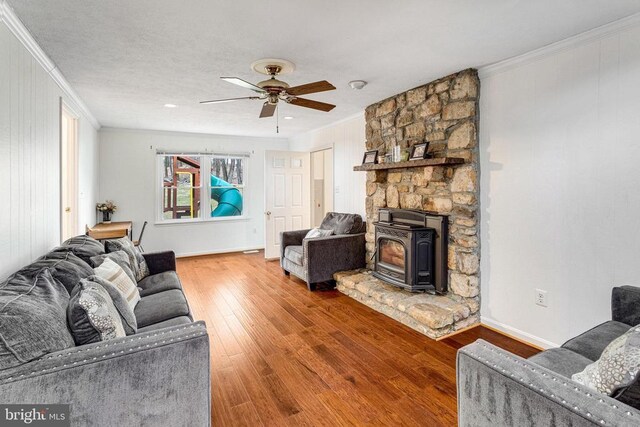 9150 James Madison Hwy, Warrenton, VA 20186 - living area featuring ornamental molding, a wood stove, ceiling fan, and wood finished floors