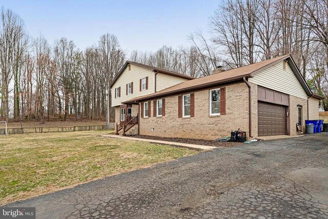9150 James Madison Hwy, Warrenton, VA 20186 - view of side of property with an attached garage, brick siding, asphalt driveway, a chimney, and a lawn
