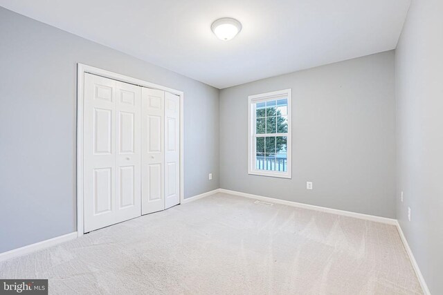 unfurnished bedroom featuring carpet floors and a closet