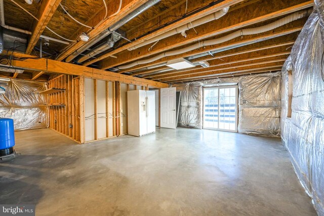 basement featuring white fridge with ice dispenser