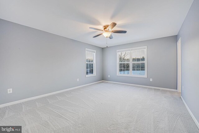 spare room featuring ceiling fan and light colored carpet