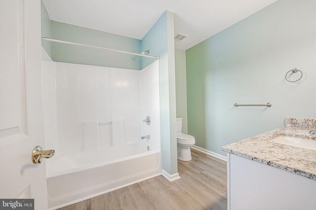 full bathroom with hardwood / wood-style flooring,  shower combination, vanity, and toilet