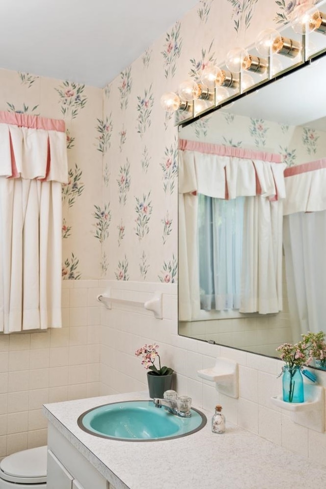 616 Lynn Ln, Waynesboro, VA 22980 - half bathroom featuring wallpapered walls, vanity, and tile walls