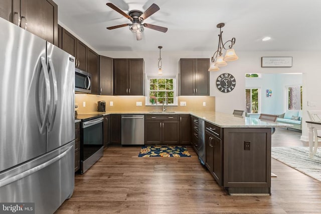 1315 Eastover Pkwy, Locust Grove, VA 22508 - kitchen with appliances with stainless steel finishes, a peninsula, dark brown cabinets, ceiling fan, and wood finished floors