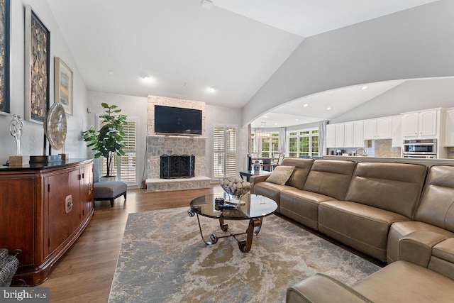 7308 Glenhaven Dr, Fredericksburg, VA 22407 - living room with lofted ceiling, wood finished floors, and a stone fireplace