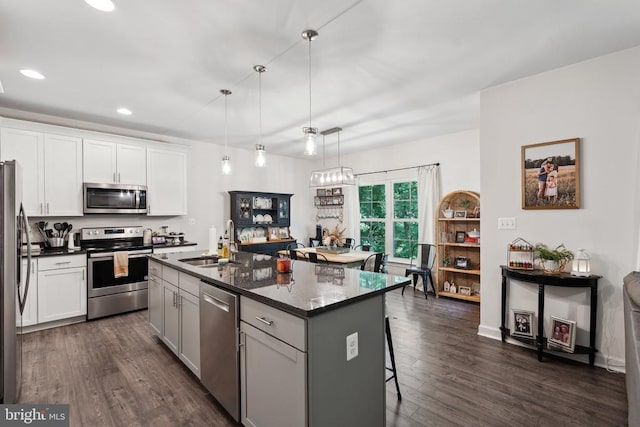 12811 Flintlock Dr, Spotsylvania, VA 22551 - kitchen featuring appliances with stainless steel finishes, a sink, recessed lighting, dark wood-style floors, and a kitchen breakfast bar