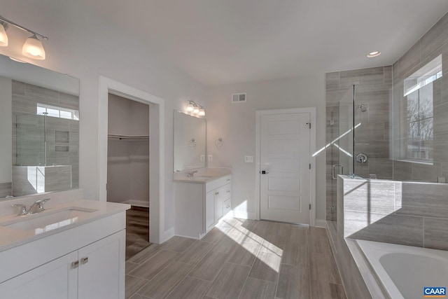 bathroom featuring a sink, visible vents, recessed lighting, a shower stall, and two vanities
