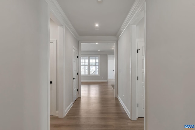 hall featuring crown molding, recessed lighting, baseboards, and wood finished floors
