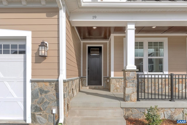 doorway to property with covered porch and stone siding