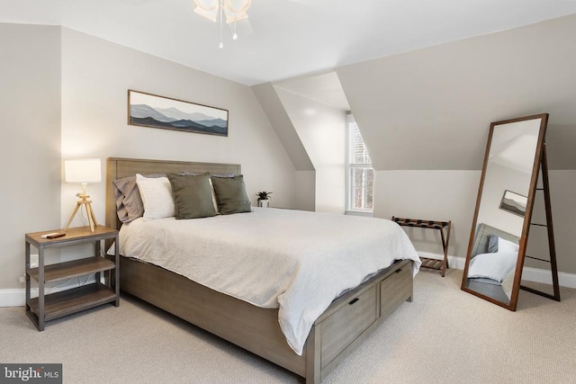 bedroom with lofted ceiling, light colored carpet, and baseboards