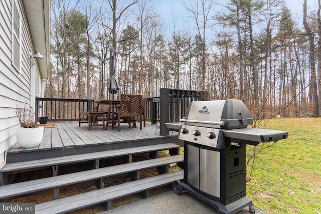 wooden deck featuring outdoor dining area, a yard, and area for grilling