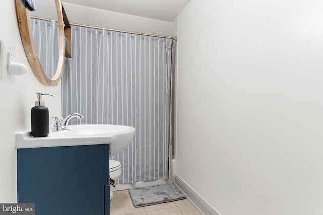 full bath featuring shower / bath combo, baseboards, toilet, tile patterned flooring, and vanity