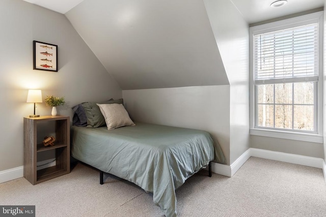 carpeted bedroom featuring vaulted ceiling and baseboards