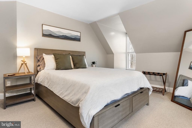 bedroom with lofted ceiling, baseboards, and light colored carpet