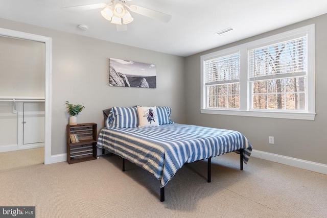 bedroom with baseboards, visible vents, and light colored carpet