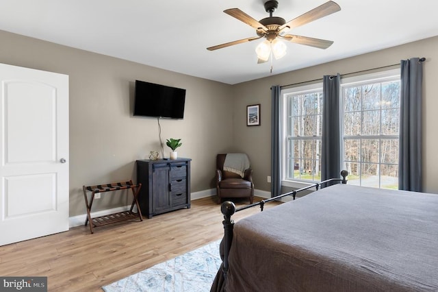 bedroom featuring a ceiling fan, light wood-type flooring, and baseboards