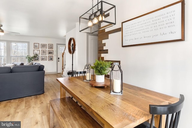 dining room featuring ceiling fan, light wood-style flooring, and baseboards