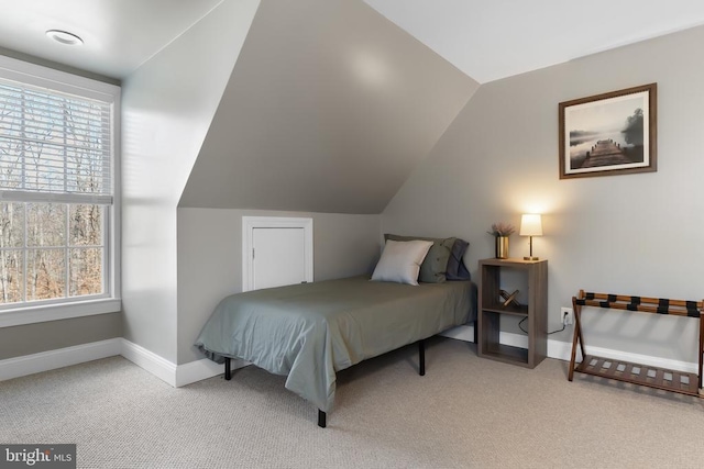 bedroom with light carpet, baseboards, and vaulted ceiling