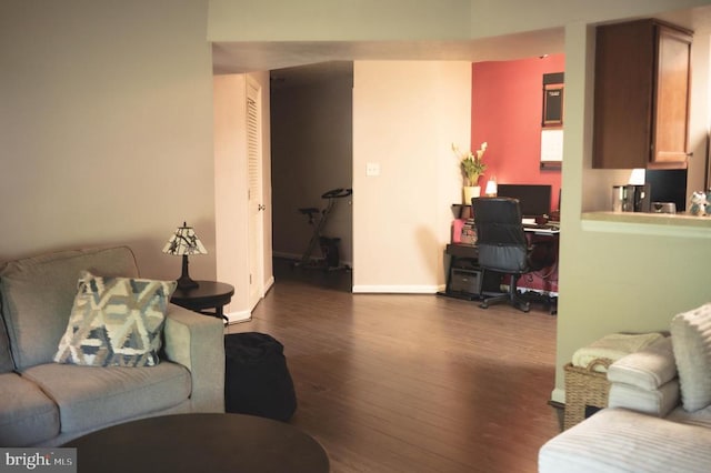 living room with a desk, dark wood-style floors, and baseboards