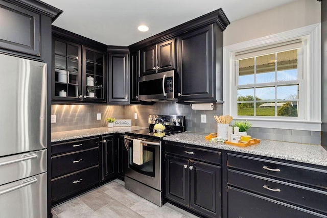 1916 Tinkling Spring Rd, Stuarts Draft, VA 24477 - kitchen featuring stainless steel appliances, dark cabinetry, decorative backsplash, and glass insert cabinets