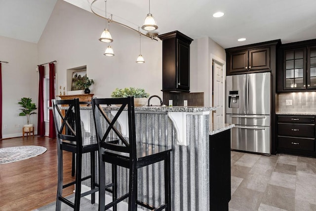 1916 Tinkling Spring Rd, Stuarts Draft, VA 24477 - kitchen featuring stainless steel refrigerator with ice dispenser, backsplash, a breakfast bar, light stone countertops, and decorative light fixtures