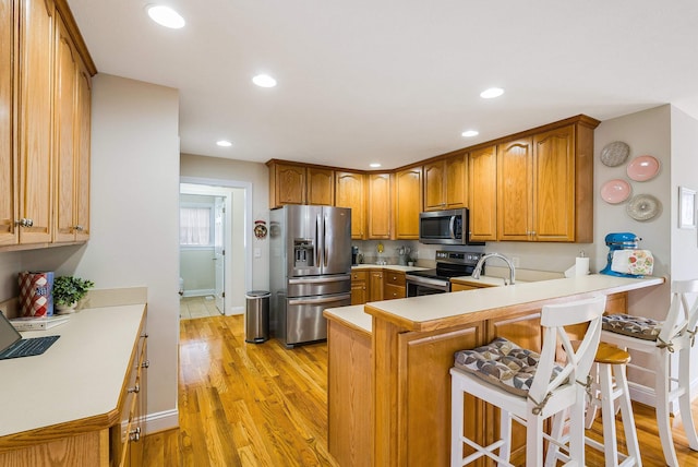 902 Waterton St, Staunton, VA 24401 - kitchen featuring stainless steel appliances, a peninsula, brown cabinetry, light wood-type flooring, and recessed lighting