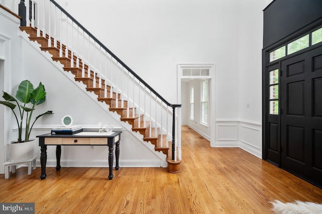 13904 Hunting Run Dr, Fredericksburg, VA 22407 - entrance foyer featuring a towering ceiling, stairway, plenty of natural light, wood finished floors, and a wainscoted wall