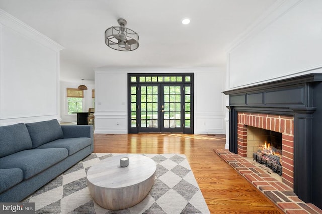 13904 Hunting Run Dr, Fredericksburg, VA 22407 - living room with a decorative wall, crown molding, light wood-style floors, a brick fireplace, and recessed lighting