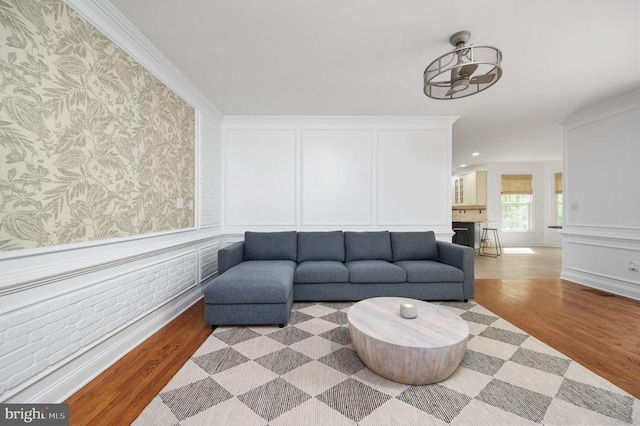 13904 Hunting Run Dr, Fredericksburg, VA 22407 - living room with wood finished floors, a decorative wall, wallpapered walls, a wainscoted wall, and ornamental molding