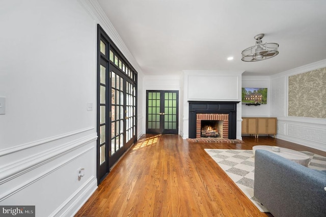 13904 Hunting Run Dr, Fredericksburg, VA 22407 - living area with french doors, a fireplace, ornamental molding, wood finished floors, and a wainscoted wall