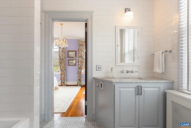 356 Routier Hill Rd, Hot Springs, VA 24445 - full bathroom featuring healthy amount of natural light, tile walls, a chandelier, vanity, and a bathtub